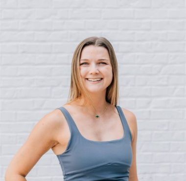 Smiling woman in gray athletic wear.