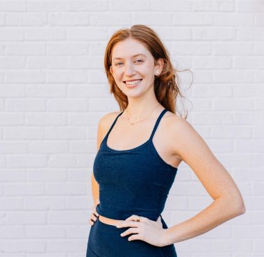 Smiling woman in blue outfit, white background.