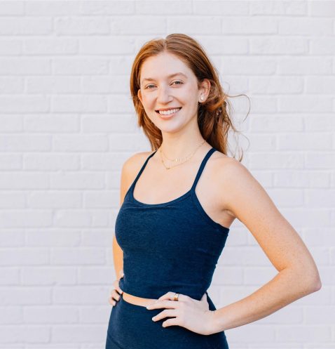 Smiling woman in blue outfit, white background.