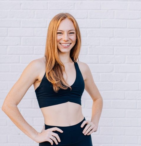 Smiling woman in athletic wear, white background.